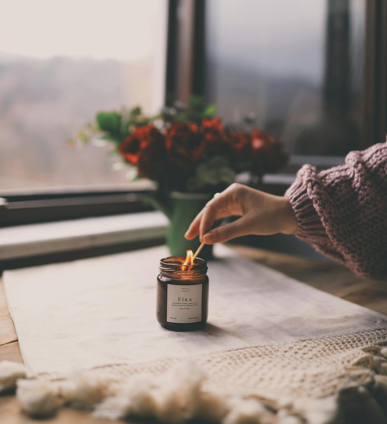 A hand lighting a candle for self care & wellbeing